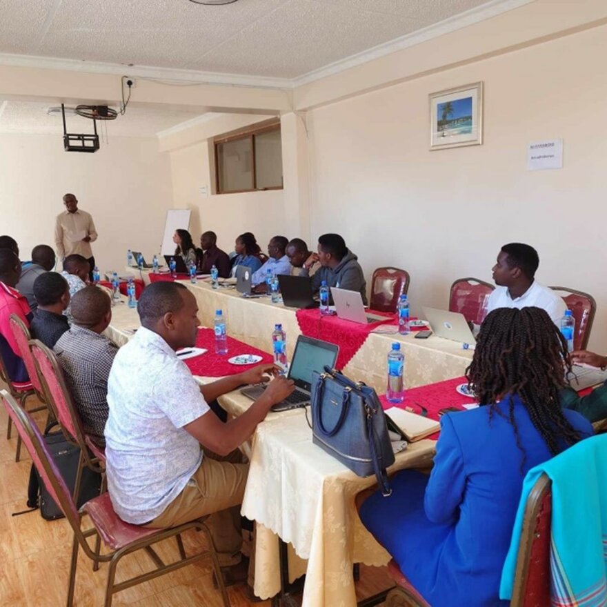 Opening of the policy dialogue, someone speaking to a group seated across a U table